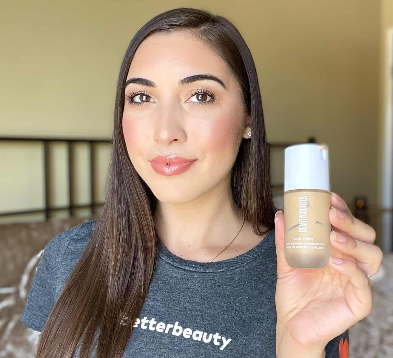 Wearing a full face of Beautycounter makeup and holding up my favorite Skin Twin Foundation.